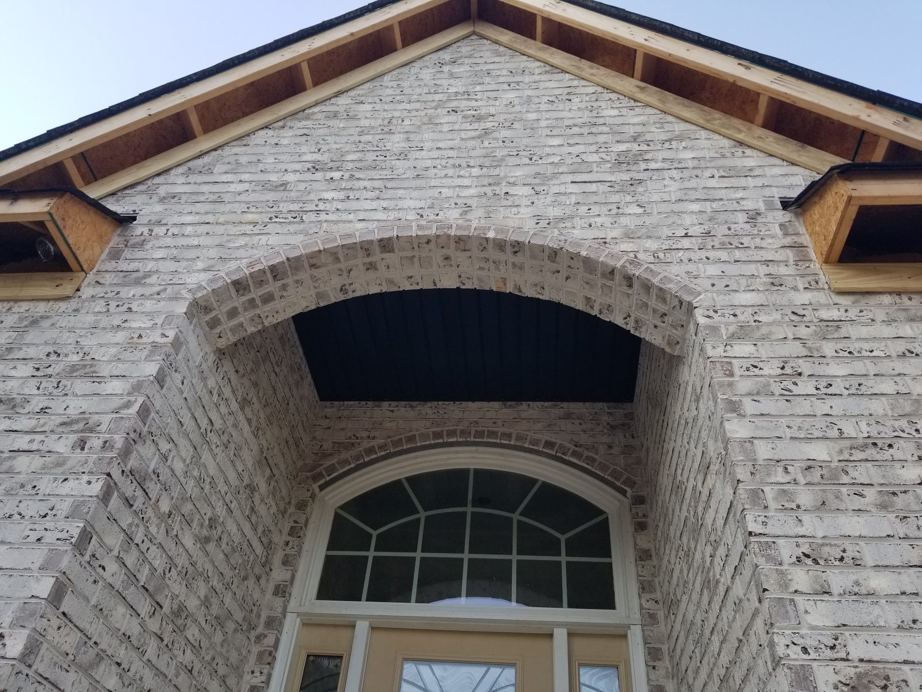 Arched brick entry detail on a custom Tessco home