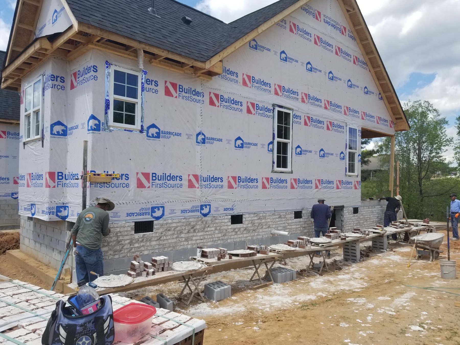 Crew laying block and framing a new home foundation